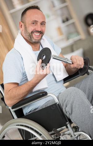 happy man in a wheelchair is doing sports Stock Photo