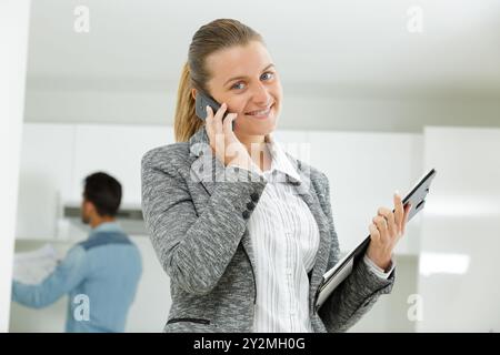 happy realtor calling someone with her mobile phone Stock Photo