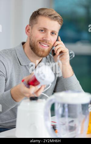 young repairman fixing and repairing kitchen devices Stock Photo