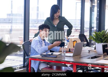 In office, discussing ideas, diverse colleagues collaborating on interior design project Stock Photo