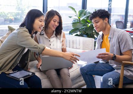 In office, collaborating on interior design project, diverse team reviewing blueprints Stock Photo