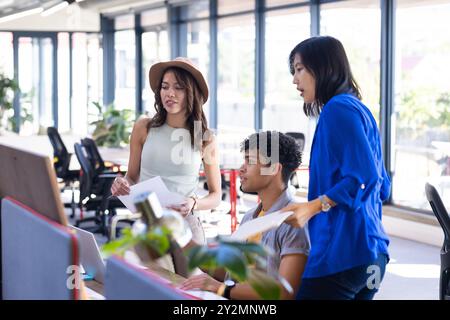 Collaborating on project, diverse team discussing design ideas in modern office Stock Photo