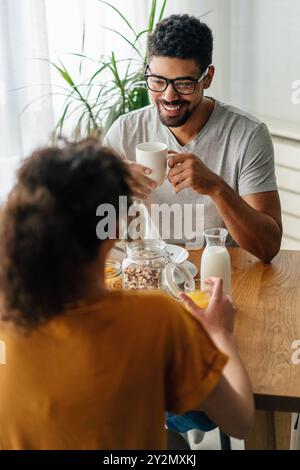 Happy african american couple having breakfast together in the kitchen Stock Photo