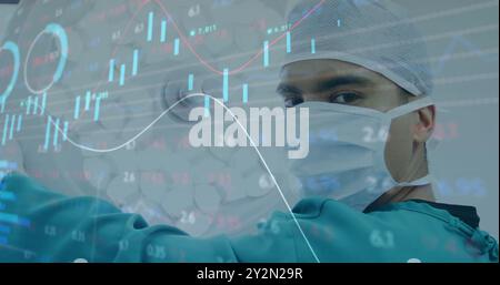 Image of statistics and data processing over caucasian male surgeon Stock Photo