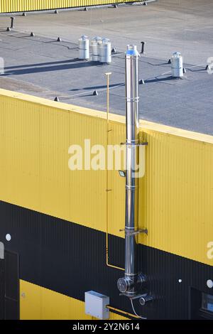 Aluminum composite panels yellow and blue commercial building facade with stainless steel chimney pipe and natural gas duct pipeline of industrial Stock Photo