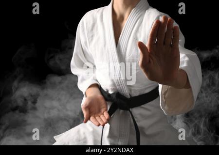 Karate fighter in smoke on black background, closeup Stock Photo