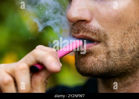 man smoking disposable electronic cigarette. face closeup Stock Photo