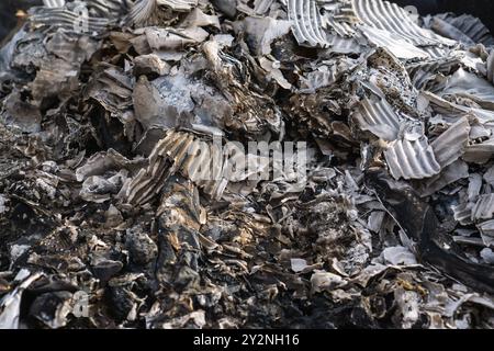 Close-up view of burnt paper and cardboard remains showcasing the texture and details of post-fire debris. Stock Photo