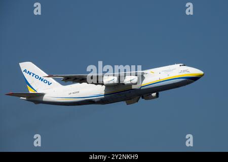 Plane Antonov 124 100M cargo aircraft in flight against a clear blue sky Antonov 124 take-off Stock Photo