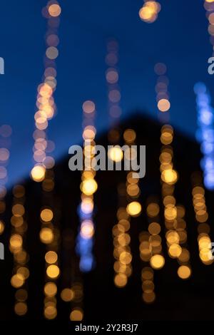 A festive photograph capturing the essence of Christmas through abstract, blurred lights creatively resembling falling snow against a deep blue twilig Stock Photo