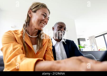 Two business multiethnic colleagues sharing informal moment of laughter during a meeting in a bright office setting Stock Photo
