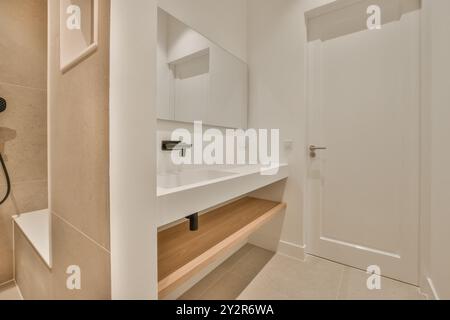 Contemporary bathroom featuring a , minimalist design with a floating vanity, integrated sink, and large mirror. Stock Photo
