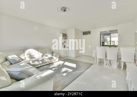 Bright and airy living room with modern white interior and sunlight casting shadows on the floor Stock Photo