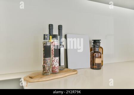 Modern kitchen countertop displaying glass bottles of oil and spices, alongside an empty label tag, inviting personal branding. Stock Photo