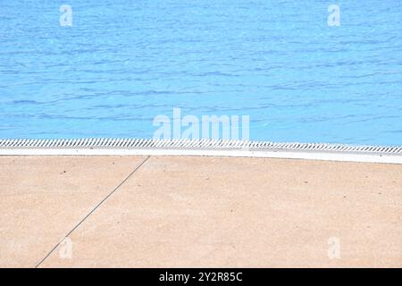 water flowing to edge of blue tile swimming pool Stock Photo