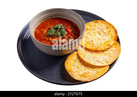 Nacho chips in black bowl with Mexican soup isolated on white background. Homemade taco chicken soup in a rustic pot with tortilla chips Stock Photo