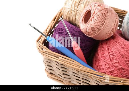 Many colorful yarns and crochet hooks in wicker basket isolated on white Stock Photo