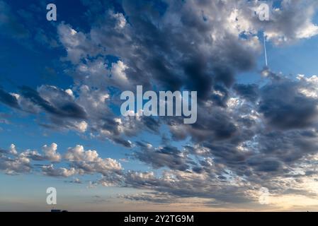 Beautiful white puffy clouds against blue sky during dramatic sunset. Stock Photo