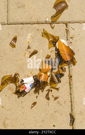 Glass from a broken bottle on an asphalt pedestrian road close-up. High quality photo Stock Photo