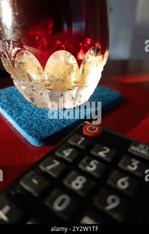 Close-up of a vodka martini and a Waterford crystal glass next to a TV remote, United States, 2024 Stock Photo