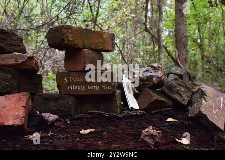 A brick, stuck in the middle, with lyric 'stuck in the middle with you' written on it - at Doll's Head Trail of Atlanta, Georgia Stock Photo