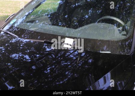 a black car with a parking ticket Stock Photo