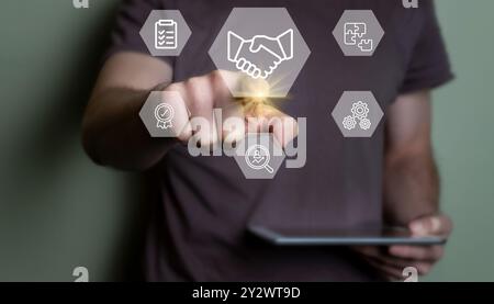 A person interacts with virtual business icons on a touchscreen, emphasizing technology and business concepts. Stock Photo