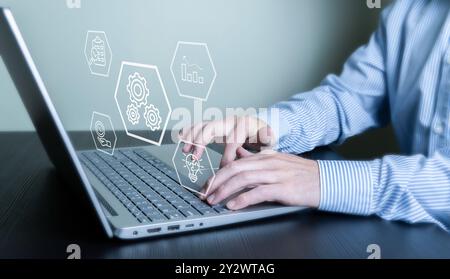 A person typing on a laptop with virtual icons representing technology and data analysis. Stock Photo