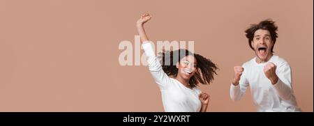 Overjoyed multiracial couple jumping in the air and celebrating success Stock Photo