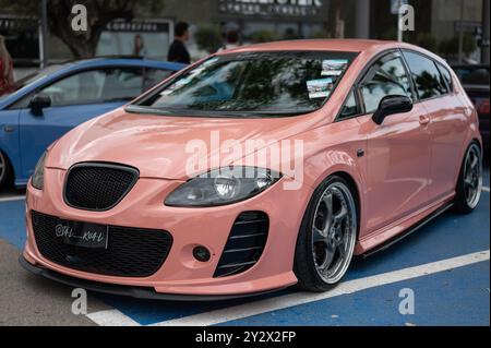 second generation Seat Leon Mk2 painted salmon color with oversized alloy wheels at a car meeting of tuned cars. This Seat is tuned Stock Photo