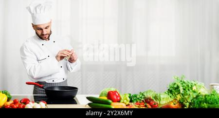 Chef Adding Pepper In Frying Pan Seasoning Dish In Kitchen Stock Photo