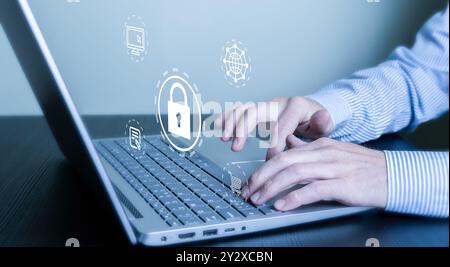 Hands typing on a laptop keyboard with cybersecurity icons overlay, representing online security and data protection. Stock Photo