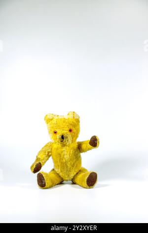 old vintage 1960s teddy bear sitting and waving on white studio background Stock Photo