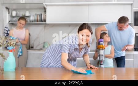 Mom is dusting the table. Father with children vacuuming room Stock ...