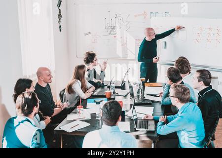 Relaxed informal IT business startup company meeting. Team leader discussing and brainstorming new approaches and ideas with colleagues. Startup business and entrepreneurship concept. Stock Photo