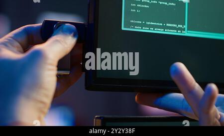 Hacker inserting USB in computer after managing to steal sensitive data, close up. Scammer uploading storage drive into PC after obtaining sensitive information from users using malware, camera A Stock Photo