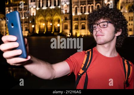 Budapest, Hungary. August 24, 2022. Amazing night shot of the parliament. The lighting enhances the beauty and elegance of the building. A young man t Stock Photo