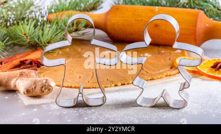 Christmas still life background - forms for gingerbread with silhouette of man and woman with ingredients for baking Stock Photo