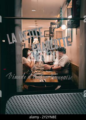 Paris - 02 September 2024 - Couple in French Restaurant Brasserie at Night having Dinner in 9th Arrondissement Stock Photo
