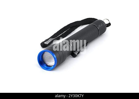 Black flashlight featuring a blue lens and wrist strap. Ideal for camping, emergencies, or everyday use. High-quality lighting tool against a white ba Stock Photo