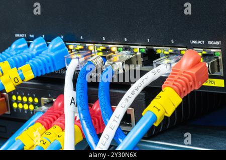 Network hub with LAN cable connected to patch cables connected to internet data center Stock Photo
