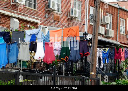 Laundry line drying on a clothesline in the backyard of a multifamily home. Stock Photo