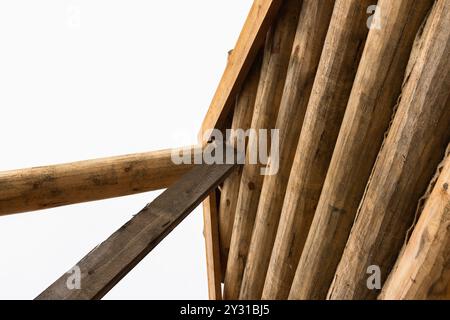 Rural wooden house made of logs is under construction, wooden parts wall is under bright sky Stock Photo