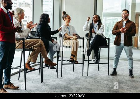 Diverse group of professionals discussing and engaging with each other during a business conference event. Collaborative atmosphere with attendees act Stock Photo