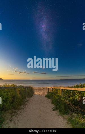 The Milky Way galaxy in the night sky over a coastal track leading to the beach at Merimbula in New South Wales, Australia Stock Photo