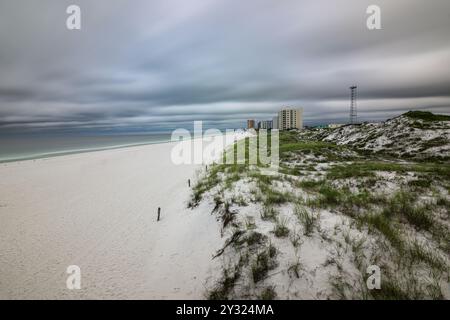 'Contrasts of Panama City Beach – where pristine white sands meet emerald waters, and a lone cell tower stands tall beneath looming storm clouds, capt Stock Photo