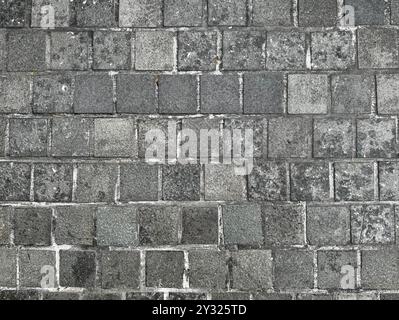 Square dark grey paving stone made of natural cobbles stone for outdoor pavement floors. Stock Photo