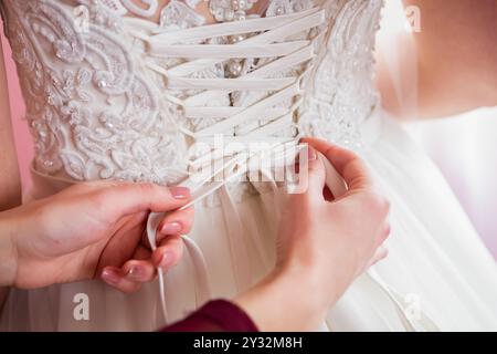 A Close-Up View of a Wedding Dress Being Laced up Before a Ceremony. Stock Photo