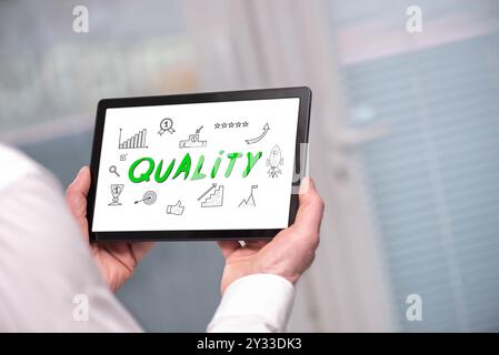 Quality concept shown on a tablet held by a man Stock Photo
