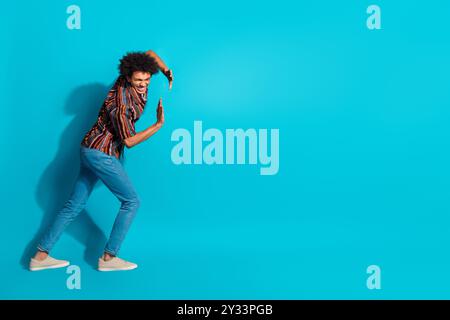 Full size photo of nice young man push empty space wear shirt isolated on teal color background Stock Photo